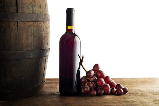 Bottle of red wine with wooden barrel background isolated on white