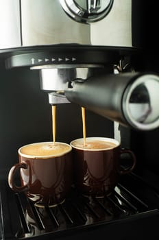 Espresso coffee pouring from coffee machine. Professional coffee brewing