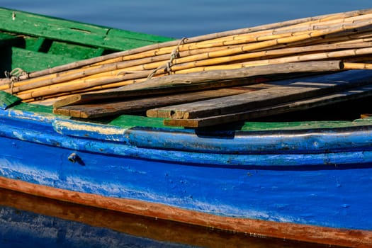 Old wooden fishing boats with bright colors at dawn on the lake. Landscape of lagoon in Sardinia south west.
