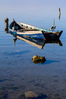 Old wooden fishing boats with bright colors at dawn on the lake. Landscape of lagoon in Sardinia south west.