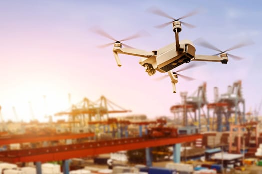 White drone with camera flying above the dock with sunset view background