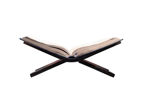 Quran open on wooden placemat isolated over white background