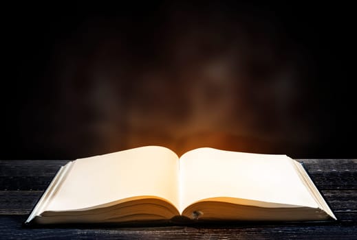 Quran open on wooden table over blurry background