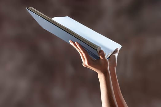 Muslim hands holding quran open over blurry background
