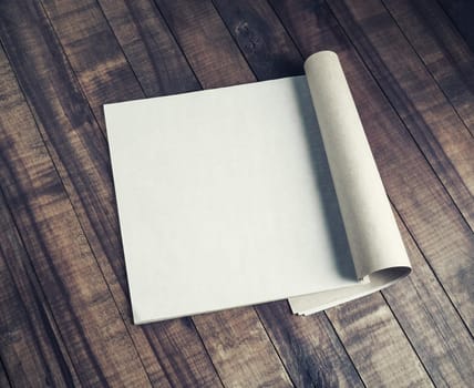 Blank open booklet on vintage wood table background. Responsive design template.