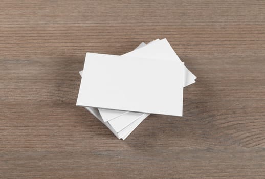 Mockup of blank business cards on wood table background.