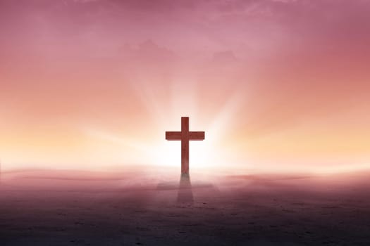 Christian cross on the desert with sun rays over sunrise background
