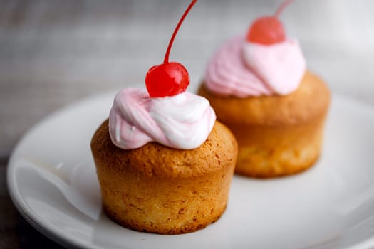Cup cakes with cream and cherry
