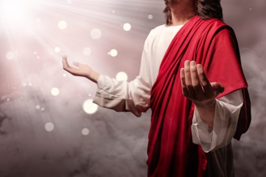 Jesus christ raised hands and praying to god with ray over blurry background