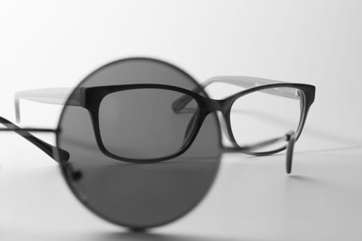 Rimmed eyeglasses closeup on a white background abstract view