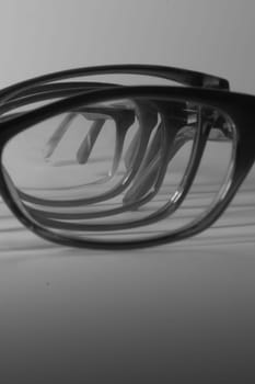 Rimmed eyeglasses closeup on a white background abstract view
