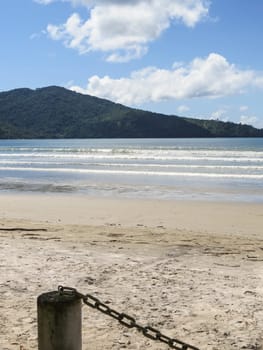 View of seaside in sunny day, with blue sky, and white clouds.