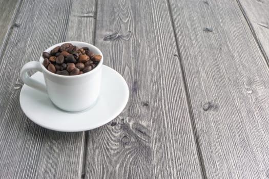 Coffee cup and coffee beans on wooden background. Top view and selective focus
