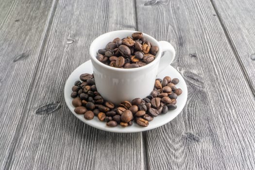 Coffee cup and coffee beans on wooden background. Top view and selective focus