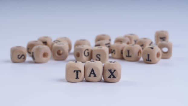 GST inscription on wooden alphabet over white background with selective focus