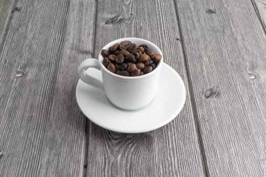 Coffee cup and coffee beans on wooden background. Top view and selective focus
