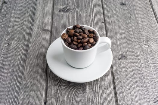Coffee cup and coffee beans on wooden background. Top view and selective focus