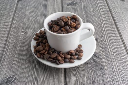 Coffee cup and coffee beans on wooden background. Top view and selective focus