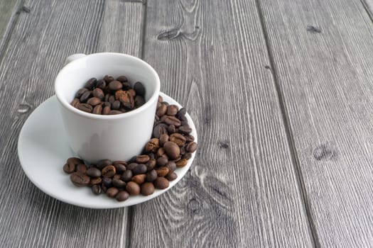 Coffee cup and coffee beans on wooden background. Top view and selective focus