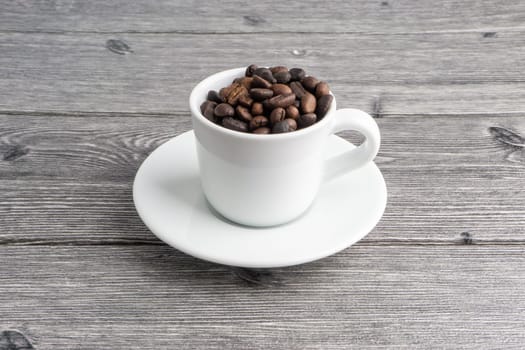 Coffee cup and coffee beans on wooden background. Top view and selective focus