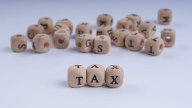 GST inscription on wooden alphabet over white background with selective focus