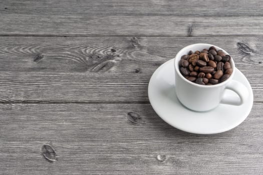 Coffee cup and coffee beans on wooden background. Top view and selective focus