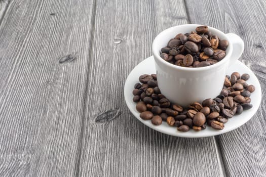Coffee cup and coffee beans on wooden background. Top view and selective focus