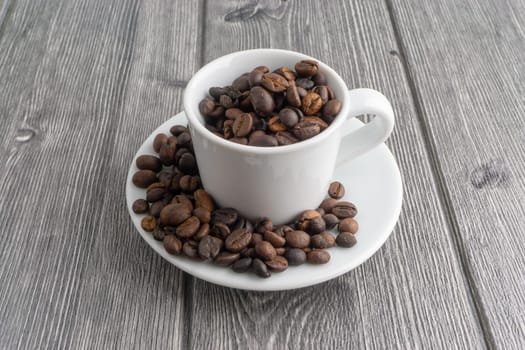 Coffee cup and coffee beans on wooden background. Top view and selective focus