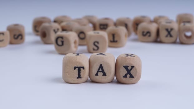 GST inscription on wooden alphabet over white background with selective focus