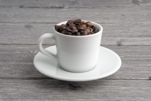 Coffee cup and coffee beans on wooden background. Top view and selective focus
