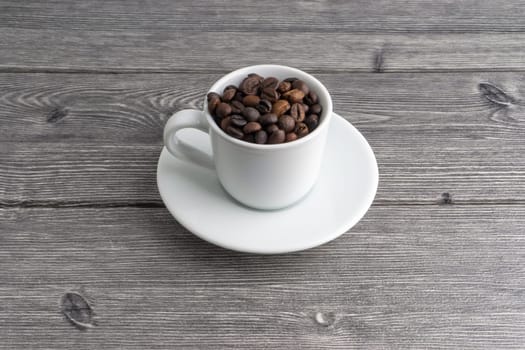 Coffee cup and coffee beans on wooden background. Top view and selective focus