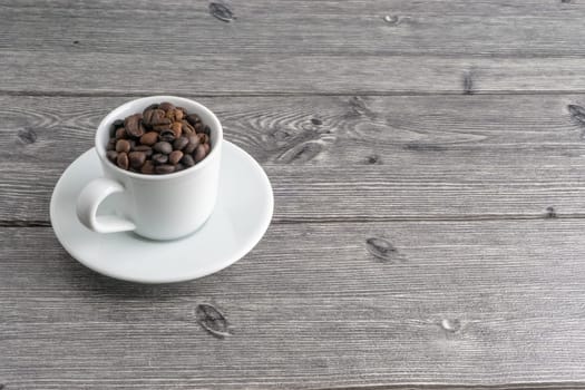 Coffee cup and coffee beans on wooden background. Top view and selective focus