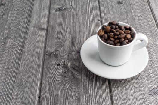 Coffee cup and coffee beans on wooden background. Top view and selective focus