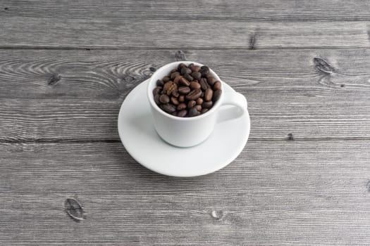 Coffee cup and coffee beans on wooden background. Top view and selective focus