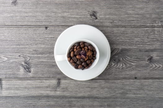 Coffee cup and coffee beans on wooden background. Top view and selective focus