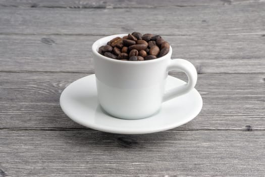 Coffee cup and coffee beans on wooden background. Top view and selective focus