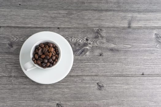 Coffee cup and coffee beans on wooden background. Top view and selective focus