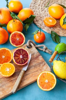 Variety of fresh citrus fruits on a blue background