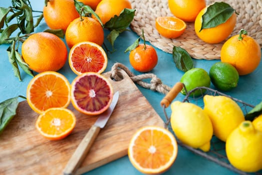 Variety of fresh citrus fruits on a blue background