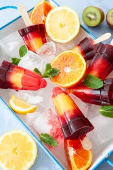 Fruity colorful ice popsicles with a variety of fresh fruits