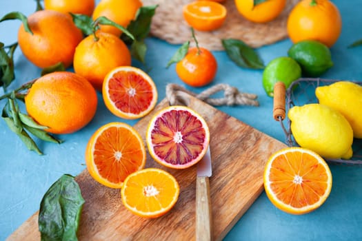 Variety of fresh citrus fruits on a blue background