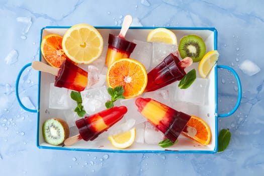 Fruity colorful ice popsicles with a variety of fresh fruits