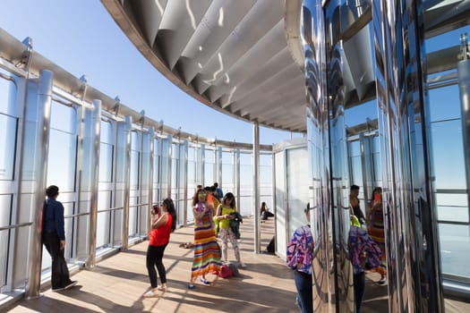 Dubai, UAE - Feb 21, 2016: Tourists taking photos of Dubai from the top the observation deck of the highest building in the world,Burj Khalifa in Dubai, UAE on 21nd of February, 2016.