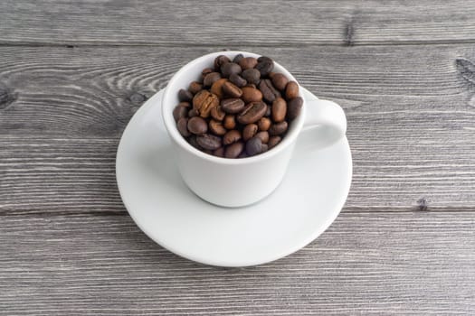 Coffee cup and coffee beans on wooden background. Top view and selective focus