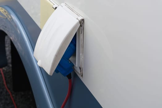 Power supply for electric car charging. Charging station for electric cars. Connecting a power supply, which is plugged into an electric car and.is charged..