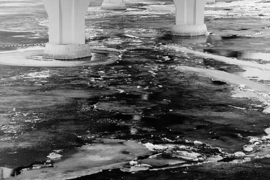 Bridge pillars in the cold water black and white background