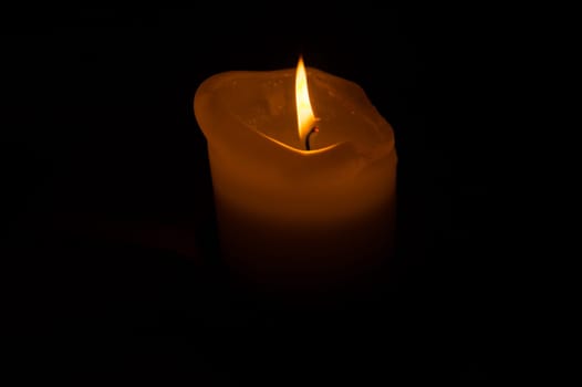 Burning candle in the dark