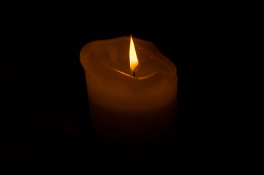 Burning candle in the dark