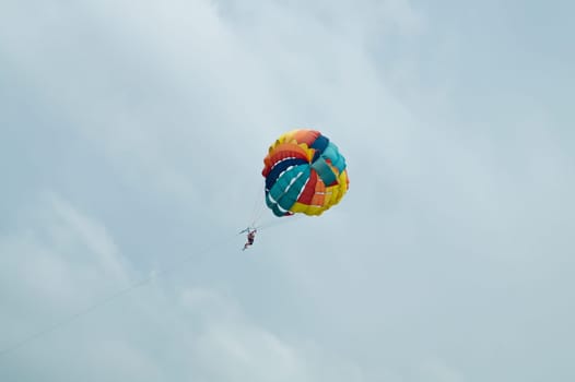 Skydiver flying with a colorful parachute