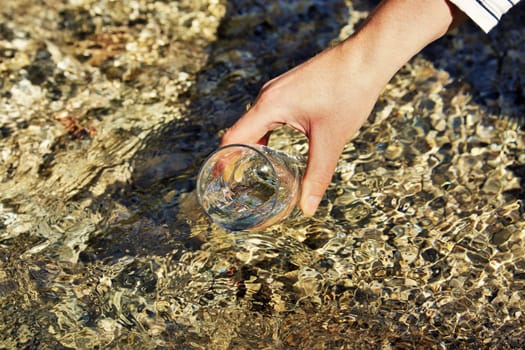 Woman's hand is holding a water glass